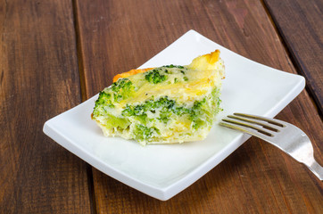 White plate with piece of egg and broccoli casserole