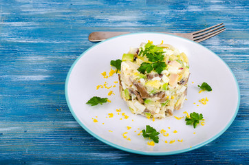 Tasty salad with squid and avocado on blue background