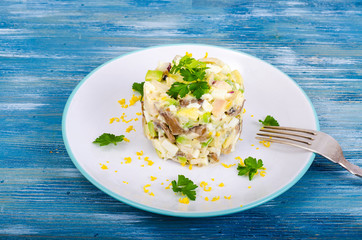 Tasty salad with squid and avocado on blue background
