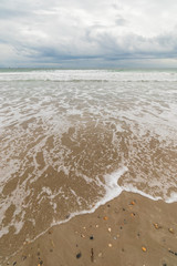 View of the sea from the beach under a stormy sky