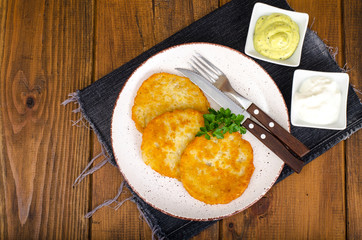 Vegetable rosti, golden fried potato pancakes with dips from cauliflower and sour cream