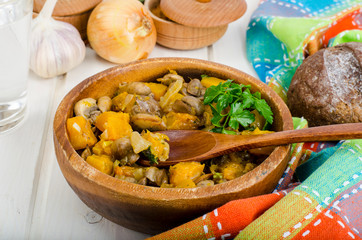 Wooden bowl with vegetable stew with mushrooms