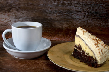 White Cup of Coffee with Chocolate Cream Cake on Old Wood Background
