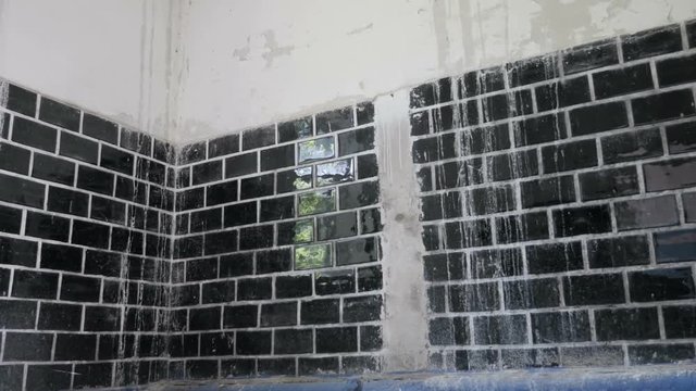 Building interior with old tiles, plaster falling off from the wall
