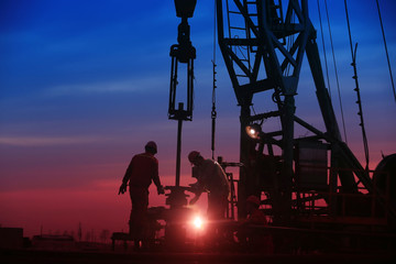 Oil workers work in the evening at the oil field