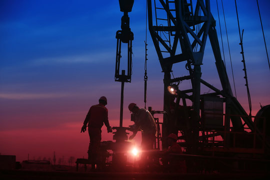 Oil workers work in the evening at the oil field