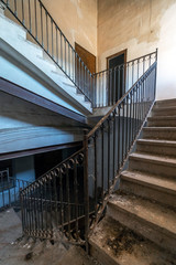 Large stairs with metal railing in abandoned house