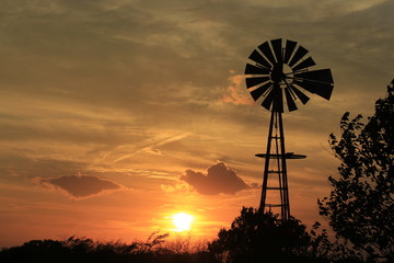 windmill at sunset with bright and colorful clouds.