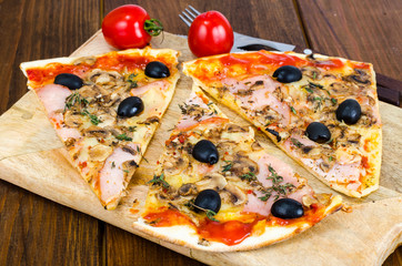 Sliced pizza with mozzarella cheese, ham, mushrooms, olives