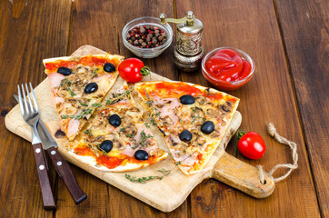 Sliced pizza with mozzarella cheese, ham, mushrooms, olives