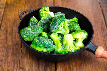Cast iron pan with frozen broccoli for cooking