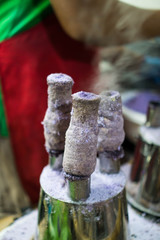 puto bumbong is a famous snack for Christmas season, it is a purple rice cooked in a tube and topped with margarine, mascovado sugar and grated coconut