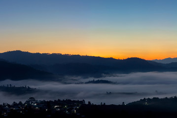Mountain and foggy at morning time with orange sky, beautiful landscape in the thailand