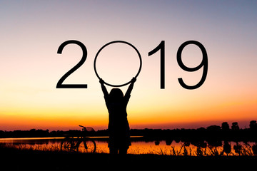 Silhouette of happy woman with New year 2019 concept in sunset background