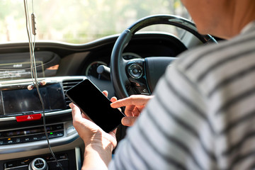 Man Hand on use mobile in car while driving.