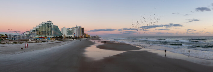 Panoramic view of a beautiful sandy beach during a vibrant sunrise. Taken in Daytona Beach, Florida, United States.