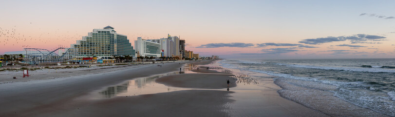 Panoramic view of a beautiful sandy beach during a vibrant sunrise. Taken in Daytona Beach, Florida, United States.