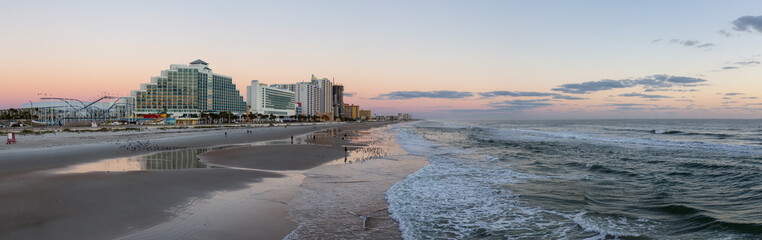 Panoramic view of a beautiful sandy beach during a vibrant sunrise. Taken in Daytona Beach, Florida, United States.