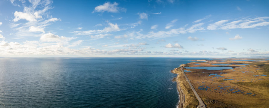 Aerial panoramic view of a scenic road during a vibrant sunny day. Taken in Newfoundland, Canada.