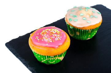 Two homemade mini cupcakes with colored icing