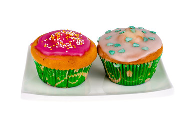 Two homemade mini cupcakes with colored icing