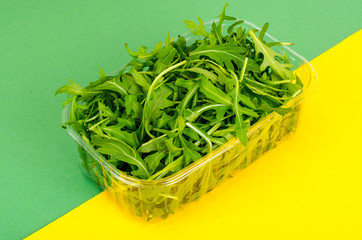 Fresh green arugula in package on color background