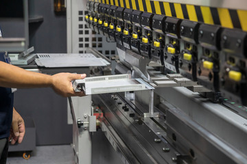 The technician operator use hydraulic bending machine. The sheet metal manufacturing process.