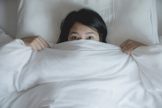 Woman With Scare And Panic While Lying Down Under The Blanket In Bedroom,Nightmare Or Bad Dream