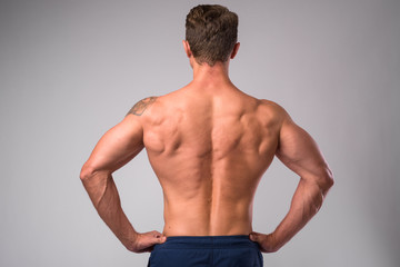 Fototapeta premium Rear view of muscular man shirtless with hands on hips