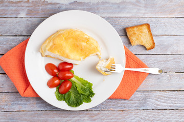 omellete and tomatoes cherry with salad leavesm top view