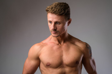 Fototapeta premium Muscular handsome bearded man thinking while looking away shirtless