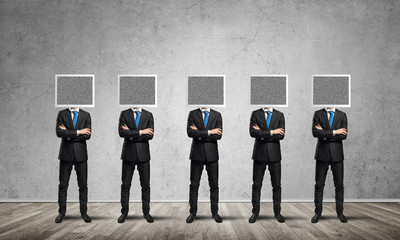 Businessmen with monitors instead of head.
