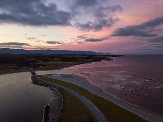 Aerial panoramic view of a beach on the Atlantic Ocean Coast during a dramatic sunrise. Taken in Codroy Valley, Newfoundland, Canada.