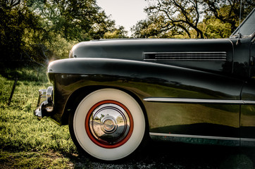 Detail of whitewall tires on classic car on a country road