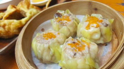 In the picture is 'Siew Mai'. This is a famous hong kong food. It is a type of traditional Chinese dumpling.