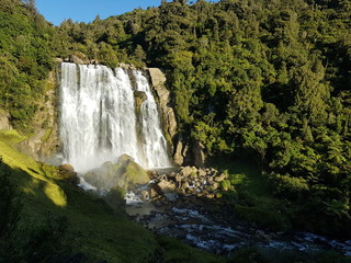 This is the Marokopa Falls in New Zealand. A waterfall is a place where water flows over a vertical drop or a series of steep drops in the course of a stream or river.