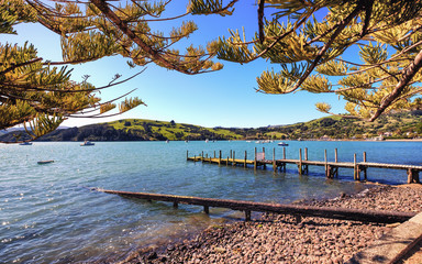 A postcard image of Akaroa in Canterbury, New Zealand. This is a charming french town with beautiful landscape. It is popular among tourist, travelers and backpackers for its nature and scenery.