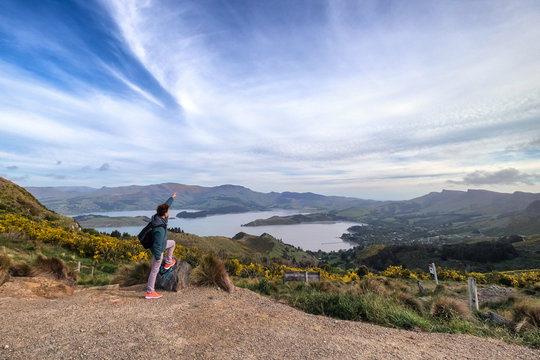 A young traveler reached the top of port hill, Christchurch, New Zealand. Inspirational concept image of a person standing on top of a mountain overlooking crater lake.