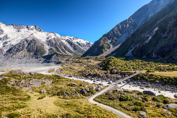 Naklejka premium The Hooker Valley, New Zealand is a popular tourists and backpackers destination. Here visitors enjoy alpine landscape, snow mountain, high suspension swing bridges, fast flowing river, and valleys.