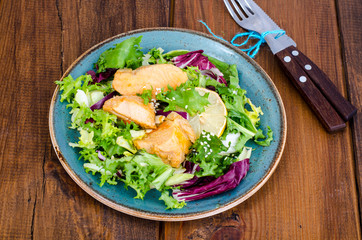 Concept of healthy food. Salad with green leaves and boiled salmon