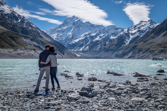 Travel Couple Cuddling Hugging At Aoraki Mount Cook National Park New Zealand