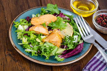 Concept of healthy food. Salad with green leaves and boiled salmon