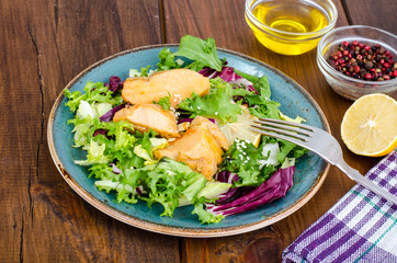 Concept of healthy food. Salad with green leaves and boiled salmon