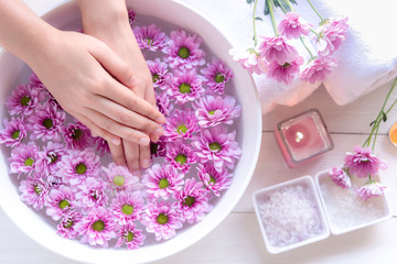 Fototapeta na wymiar Spa treatment and product for female feet and manicure nails spa with pink flower, copy space, select focus, Thailand. Healthy Concept