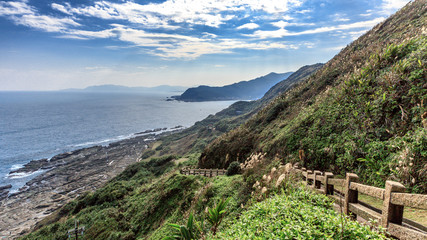 This is a breathtaking view of a hiking trail in Taiwan. A staircase leads downhill along the edge of the cliff. The stairs are steep. This is popular destination among tourist, locals and hikers.