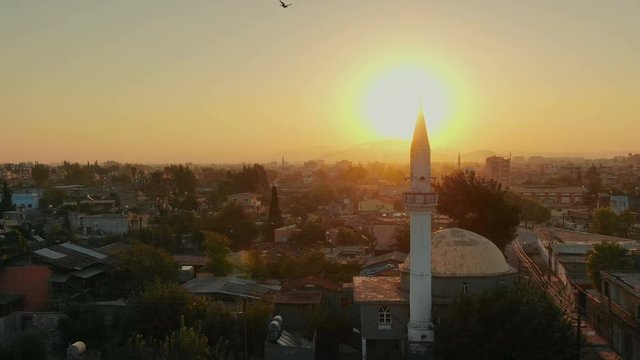 Flight above Muslim town with mosque minaret and residential buildings. Flug &uuml;ber muslimischer Stadt mit Moscheen-Minarett und Wohngeb&auml;uden. Luftbild und Fliegen &uuml;ber Stadtgebiet mit Stra&szlig;en