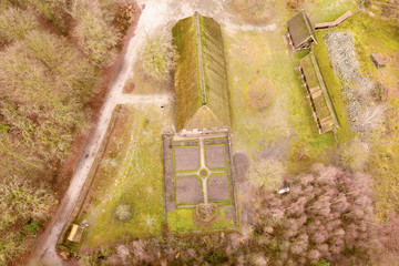 Main house in the open-air museum Hösseringen in the Lünebürger Heide near Suderburg from the air, with a geometrically arranged farm garden in front of the entrance of the stately building.