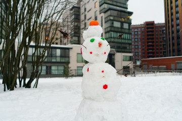 snowman snow sculpture with a nose of carrots. made by children.