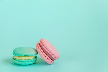 Sweet almond colorful pink blue macaron or macaroon dessert cake isolated on trendy blue pastel background. French sweet cookie. Minimal food bakery concept. Flat lay top view copy space