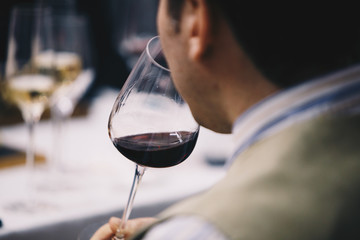 A glass of red wine in hand